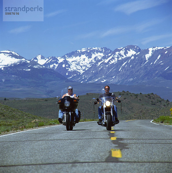 Harley Davidson Biker mit schneebedeckten Bergen im Hintergrund  Vereinigte Staaten von Amerika  Nordamerika