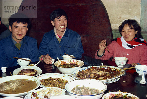 Lokale Familie mit Schalen Essen bei einem Bankett in der chinesischen Provinz Sichuan  China  Asien