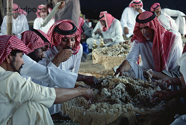 Gruppe von Männern Essen auf einem Beduinen fest  Saudi Arabien  Naher Osten