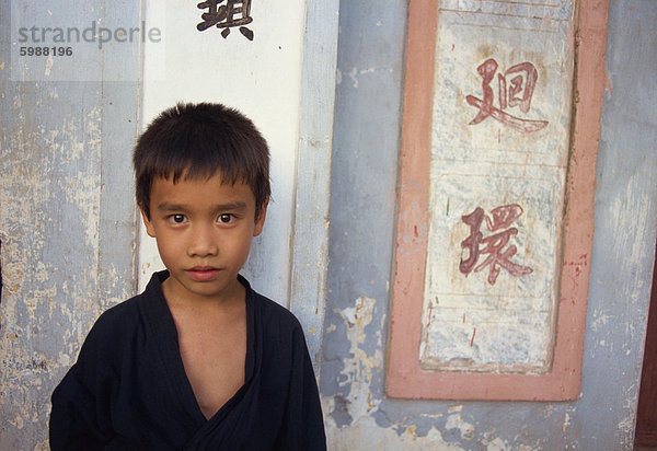 Porträt eines kleinen Jungen neben chinesischen Schriftzeichen an der Wand  in Vietnam  Indochina  Südostasien  Asien