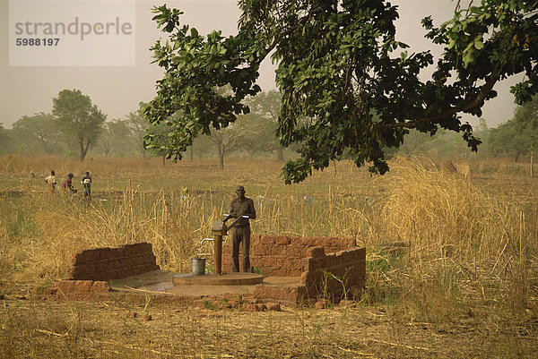 Mann mit Wasser-Pumpe  Burkina Faso  Westafrika  Afrika