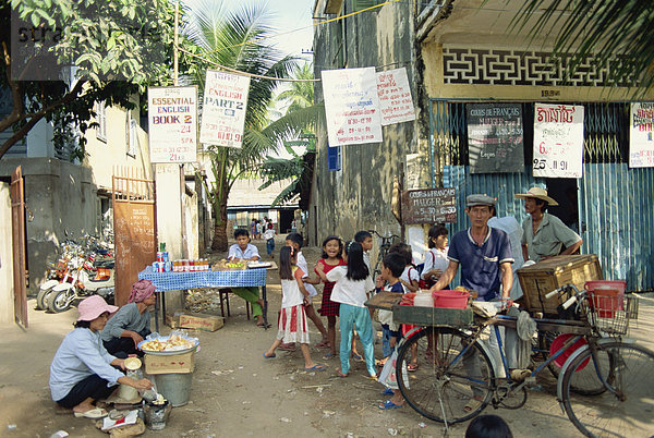 Englisch Street mit Zeichen  Imbissstände und Mann mit Fahrrad in der Stadt Phnom Penh  Kambodscha  Indochina  Südostasien  Asien