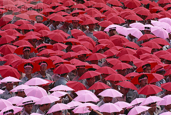 Menschenmassen tragen rot und Rosa Regenschirm Hüte während der jährlichen Doppel zehn Nationalfeiertag in Taipei  Taiwan  Asien