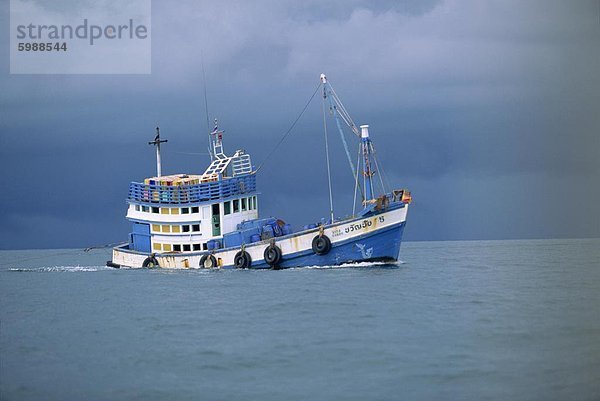 Fischerboot auf dem Meer unter stürmischen Himmel vor der Küste in der Nähe von Krabi  Thailand  Südostasien  Asien