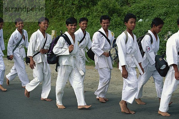 Lokale junge Männer auf ihrem Weg nach draußen Karate Praxis Berastagi  Karo Hochland  Sumatra  Indonesien  Südostasien