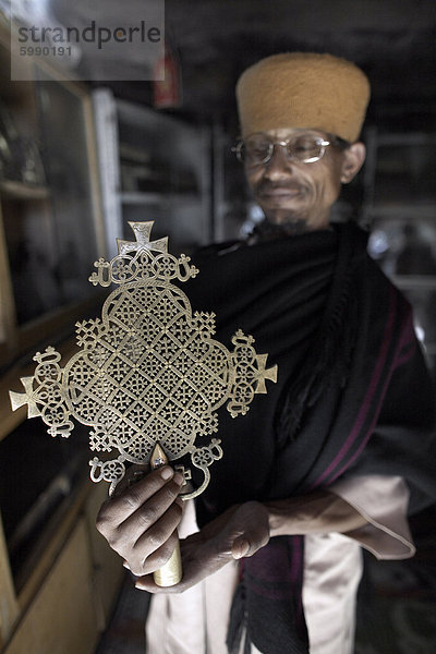 Ein Priester hält ein Kreuz am Kloster von Kebran Gabriel  auf einer Insel auf See Tana  Äthiopien  Afrika