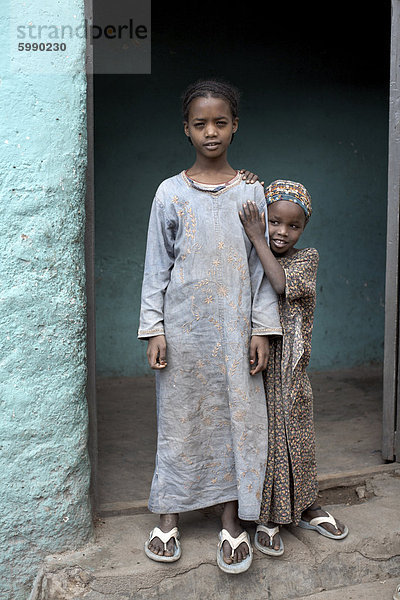 Junge Schwestern posieren für ein Foto außerhalb ihrer Heimat in die Gassen von Harar  Äthiopien  Afrika