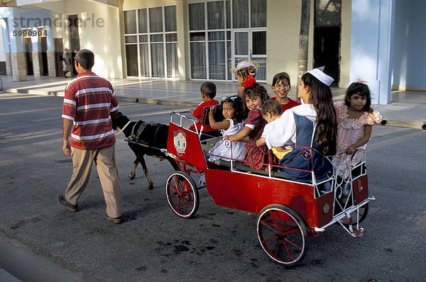 Ziege Karre mit Kindern an einem Sonntag in der Plaza De La Revolucion  Bayamo  Kuba  Westindische Inseln  Mittelamerika