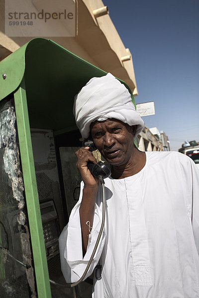 Sudanesischer Mann über ein Telefon in der Stadt von Karima  Sudan  Afrika