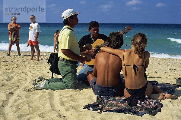 Paar sitzt am Strand anhören der beiden Musiker  La Habana  Kuba  Westindische Inseln  Mittelamerika