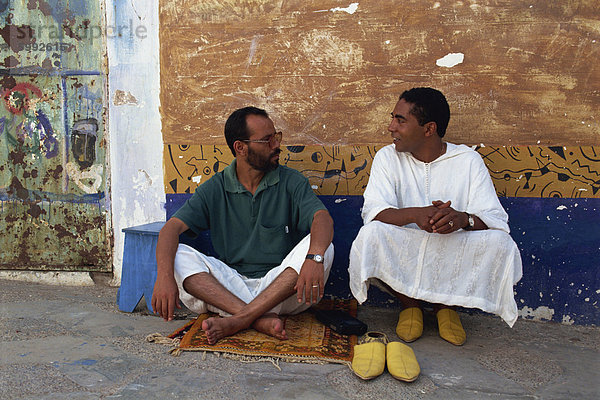 Porträt von zwei Männer sitzen im freien Gespräch auf der Straße  Asilah  Marokko  Nordafrika  Afrika