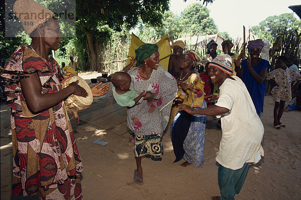 Kleine Gruppe von Menschen  darunter Frau mit ihrem Baby  Tanz im Freien  Gambia  Westafrika  Afrika