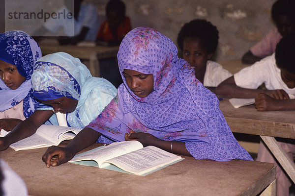Porträt von Schulkindern an Tischen  lesen in einer Schule Klassenzimmer  Somalia  Afrika
