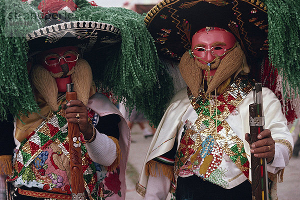 Porträt zweier Männer tragen Masken  Kostüme  Sombreros und tragen von Waffen  während des Karnevals Huejotzingo in Mexiko  Nordamerika