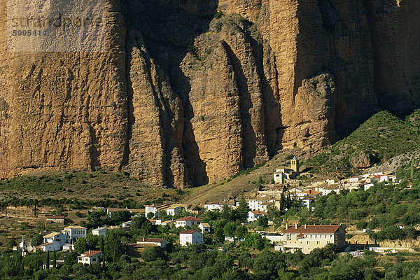 Dorf in den Schatten gestellt durch die Pudding-Stein-Klippen von Mallos de Riglos  Riglos  Huesca  Aragonien  Spanien  Europa