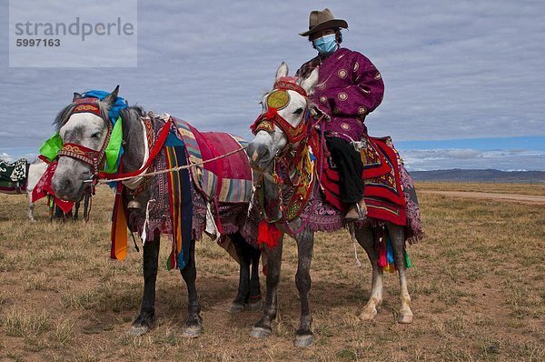 Reiter auf Colourfuly gekleidet Pferd in der Steppe von westlichen Tibet  China  Asien
