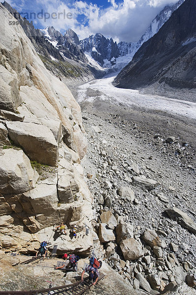 Kletterer auf einer Leiter auf einer Felswand über dem Mer de Glace  Mont Blanc Massiv  Chamonix  französische Alpen  Frankreich  Europa