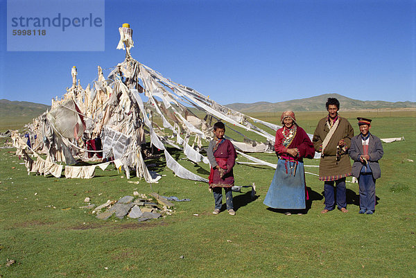 Eine Familie stehen neben Gebetsfahnen am Huashixia in Qinghai  China  Asien