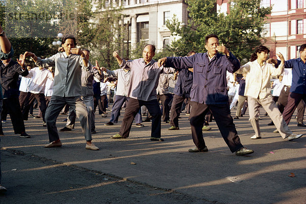 Eine Gruppe von Männern und Frauen Tai-Chi-Übungen an der frischen Luft auf dem Bund in Shanghai  China  Asien