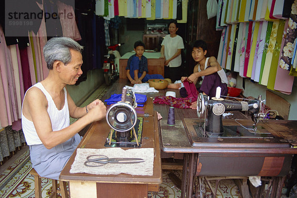 Schneider Arbeiten bei einer Nähmaschine und seiner Familie  in ihrem Shop in der Altstadt von Hanoi  Vietnam  Indochina  Südostasien  Asien