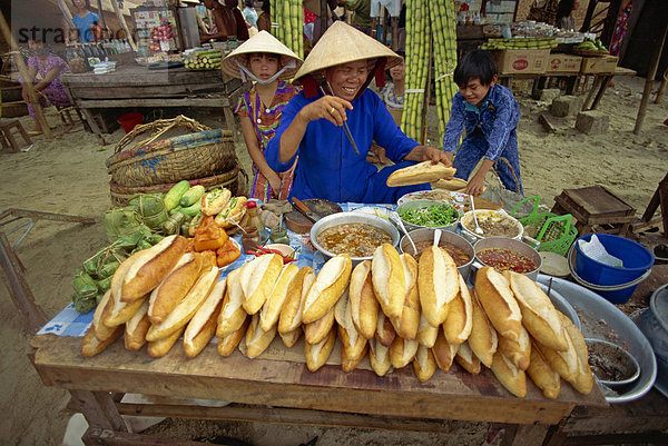 Frau Straßenhändler verkaufen Baguette Brötchen aus ihrem Stand auf dem Bürgersteig in Nhatrang  Vietnam  Indochina  Südostasien  Asien
