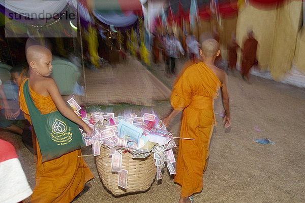 Zwei junge Mönche mit Korb Spenden während der Pha  Luang Festival während der buddhistischen Fastenzeit  an die große Stupa in Vientiane  Laos  Indochina  Südostasien  Asien
