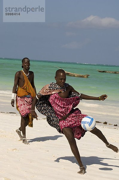 Maasai Stammesangehörigen in bunten native Kleid spielen Fußball am Strand  Afrika  Ostafrika  Paje  Zanzibar  Tansania