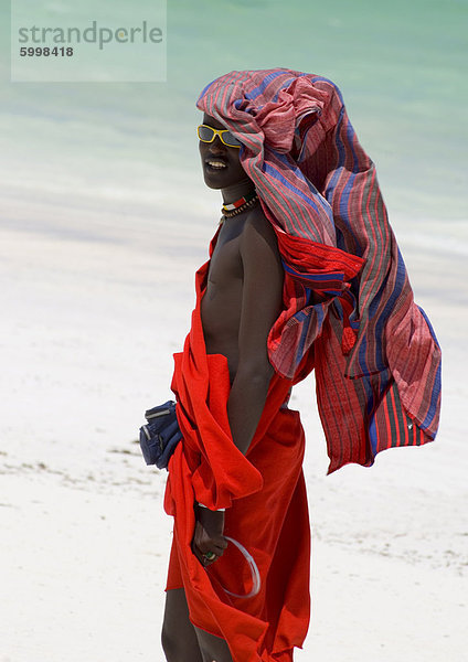 Ein Maasai Stammesangehörige auf Paje Beach bunte native Kleid  Paje  Zanzibar  Tansania  Ostafrika  Afrika