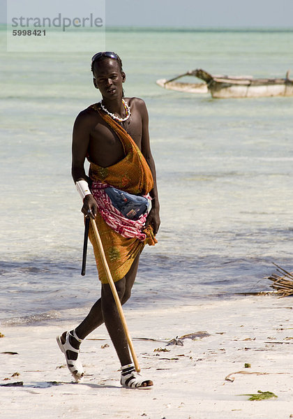 Ein Maasai Stammesangehörige auf Paje Beach bunte native Kleid  Paje  Zanzibar  Tansania  Ostafrika  Afrika