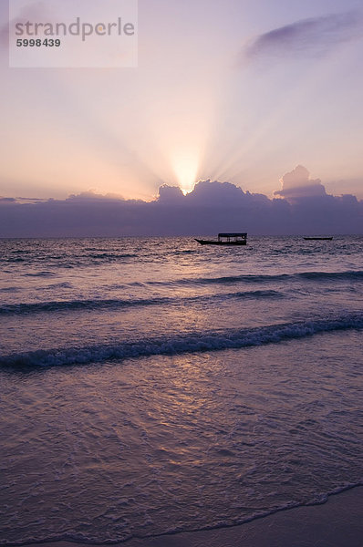 Ein altes hölzernes Boot im Meer bei Sonnenaufgang  Paje  Zanzibar  Tansania  Ostafrika  Afrika