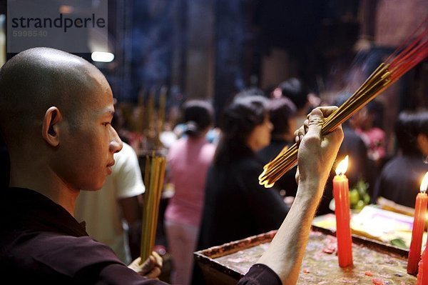 ' Mönch Beleuchtung Räucherstäbchen während der Zeremonie in einem buddhistischen Tempel  Ho Chi Min-Stadt  Vietnam  Indochina  Südostasien  Asien & # 10