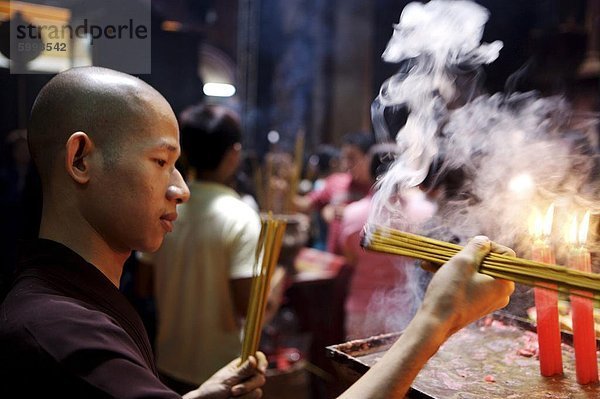 ' Mönch Beleuchtung Räucherstäbchen während der Zeremonie in einem buddhistischen Tempel  Ho Chi Min-Stadt  Vietnam  Indochina  Südostasien  Asien & # 10