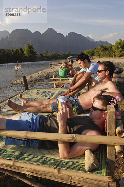 Rucksacktouristen entspannen am Fluss Nam Song in Vang Vieng  Laos  Indochina  Südostasien  Asien