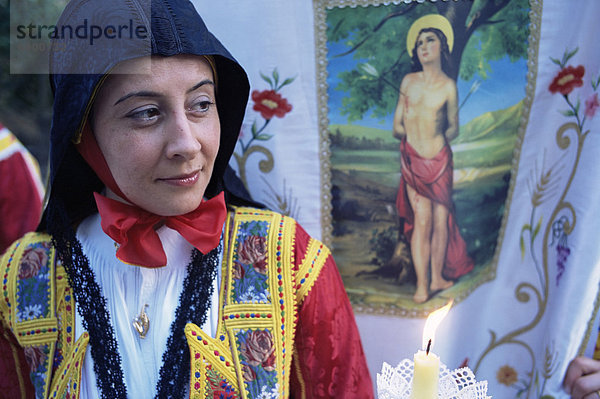 Frau vor religiösen Banner  Corpus Domini Prozession  Desulo (Gennargentu)  Sardinien  Italien  Europa