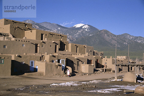 Lady fegt  nachdem Besucher haben abreiste  mehrstöckige Adobe-Gebäude im Norden Komplex aus um 1450 N.  Taos Pueblo  UNESCO Weltkulturerbe  Taos  New Mexico  Vereinigte Staaten von Amerika (U.S.A.)  Nordamerika