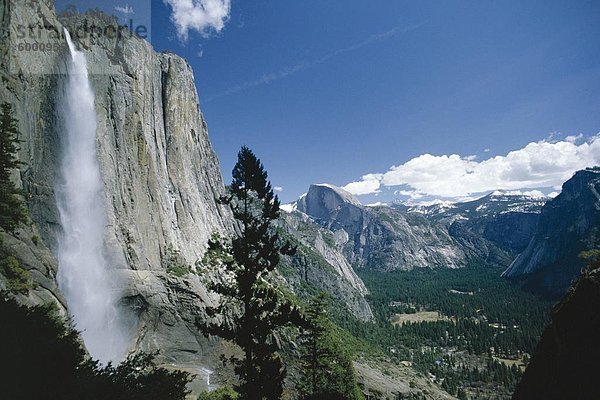 Upper Yosemite Falls Kaskaden die schiere Granit Mauern des Yosemite Valley  der Welt längste ununterbrochene fallen  mit dem berühmten 8842 ft Half Dome in der Ferne  Yosemite National Park  UNESCO Weltkulturerbe  California  Vereinigte Staaten von Amerika (U.S.A.)  Nordamerika