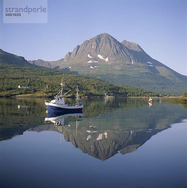 Boot und Berge spiegeln sich in ruhigen Wasser  in der Nähe von Tromsø  Norden  Norwegen  Norwegen  Skandinavien  Europa