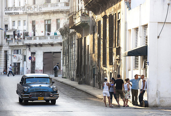 Straßenszene Ergebnis alten amerikanischen Auto Betrieb als Taxi für einheimische und eine Warteschlange von Menschen außerhalb ein Geschäft  Havanna  Kuba  Westindische Inseln  Mittelamerika