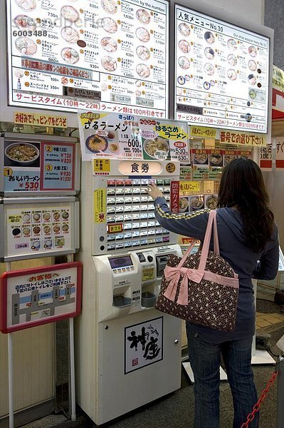 Frau Kauf Mahlzeit Tickets aus dem Automaten in einem Restaurant in Dotonbori  Osaka  Japan  Asien