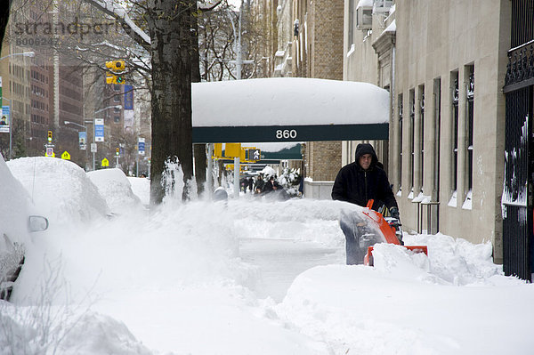 Ein Mann mit eine Schneefräse an der Park Avenue nach einem Schneesturm in New York City  New York State  Vereinigten Staaten von Amerika  Nordamerika