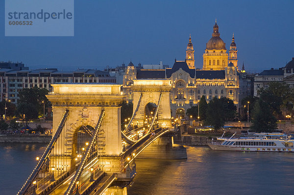 Nachtansicht der Kettenbrücke (Szechenyi Lanchid)  beleuchtet  über die Donau das Gresham Hotel  St.-Stephans Basilika und der Pestseite hinter  Budapest  Ungarn  Europa