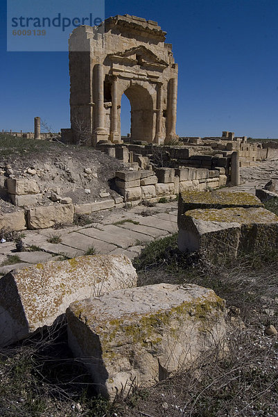 Ost-West-Straße  mit Arch von Trajan hinter  römische Ruinen von Makhtar  Tunesien  Nordafrika  Afrika