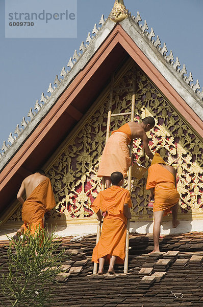 Mönche auf Dach malen die Tempel Dekorationen  Wat Mai  Luang Prabang  Laos  Indochina  Südostasien  Asien