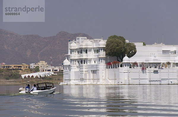 Ein kleines Boot in Richtung das Lake Palace Hotel am Lake Pichola in Udaipur  Rajasthan  Indien  Asien