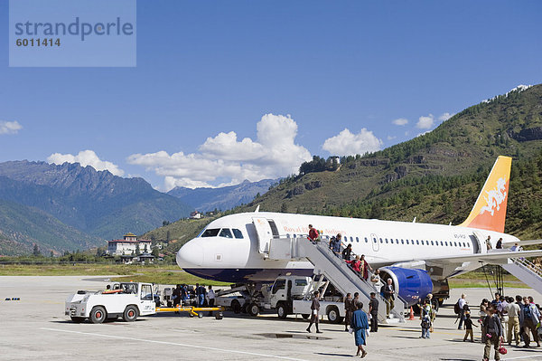 Passagierflugzeug auf dem Flughafen Paro  Paro Rinpung Dzong in der Distanz  Paro  Bhutan  Himalaya  Asien