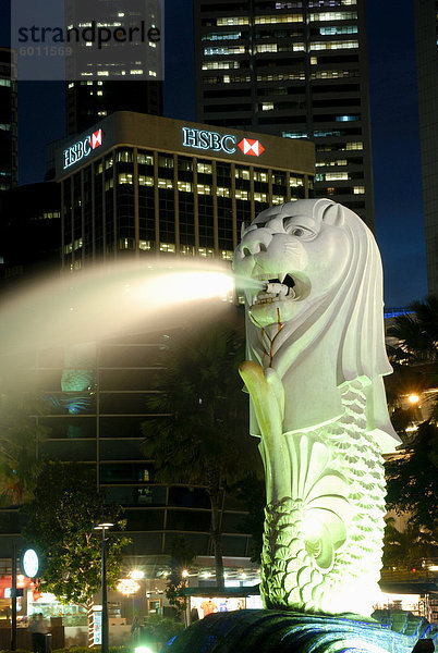 Merlion Brunnen mit Statue des halb Löwe und Fische  die ein Symbol von Singapur  mit Gebäude der Stadt darüber hinaus  Singapur  Südostasien  Asien geworden ist