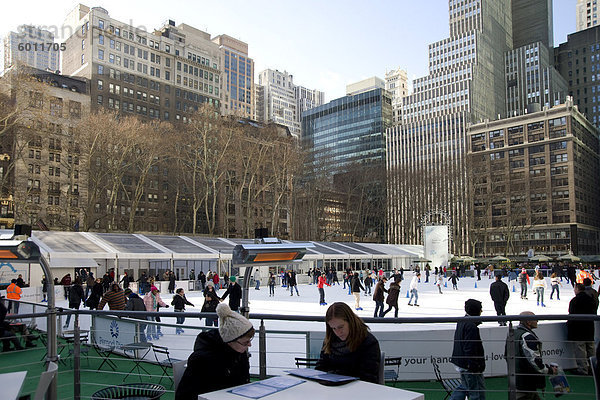 Leute sitzen in einem Café neben der Eislauffläche im Bryant Park  New York City  New York State  Vereinigten Staaten von Amerika  Nordamerika