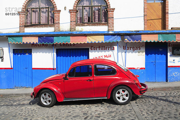 Roten Volkswagen Käfer parkte auf gepflasterten Straße  Tepoztlan  in der Nähe von Mexiko-Stadt  wo viele Stadtbewohner Wochenende  Morelos  Mexiko  Nordamerika verbringen