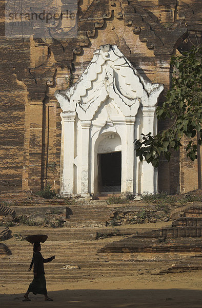 Silhouette einer Frau mit Tablett auf ihrem Kopf zu Fuß vorbei an Stupa Eingang  Mingun Paya  in der Nähe von Mandalay  Myanmar (Birma)  Asien
