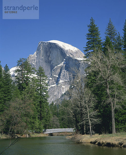 Bäume neben einem Fluss Rahmen Schnee bedeckten Berg Half Dome im Yosemite-Nationalpark  UNESCO Weltkulturerbe  California  Vereinigte Staaten von Amerika  Nordamerika